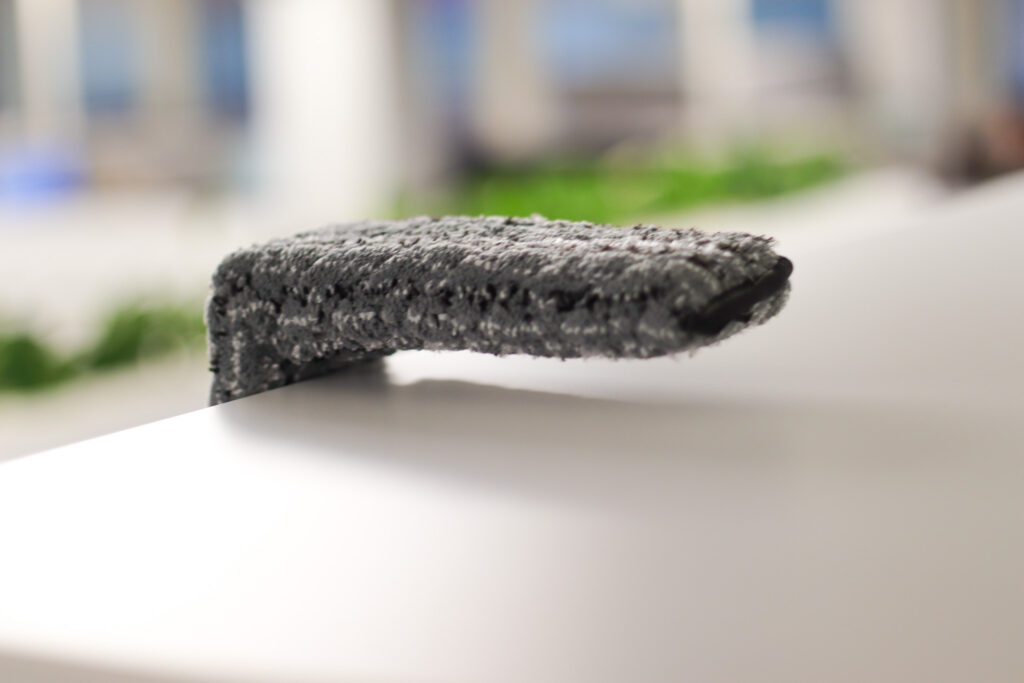 N-Cleanin siivooja poistaa yläpölyjä toimiston kaapin päältä